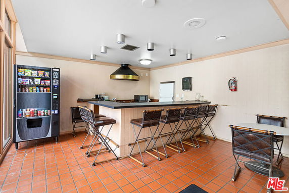 Indoor clubhouse area with a snack vending machine, bar counter, and seating.