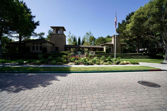 Front view of a single-story house with a tower feature and landscaped garden.
