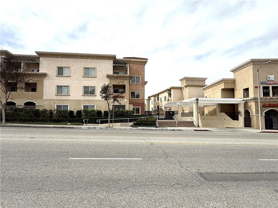 Front view of a multi-story apartment building with a gated entrance.