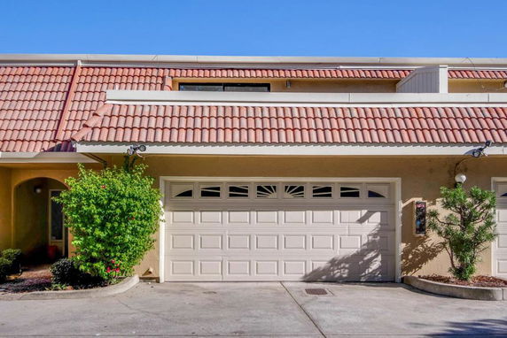 Front view of a building with a tiled roof and a double garage.