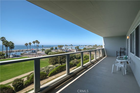 Panoramic view from a building's balcony overlooking a waterfront and marina.