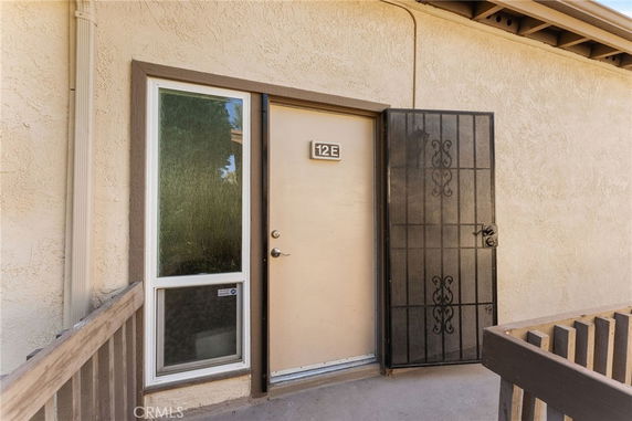 Entrance of a building featuring a security door and unit number 12E.