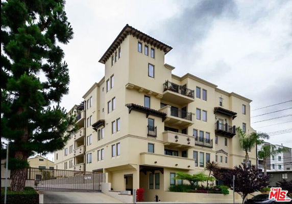 Front view of a multi-story apartment building with balconies.