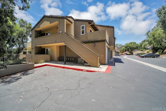 Front view of a multi-story residential building with external staircase.