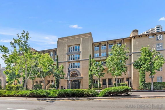 Front view of a multi-story building with large windows and decorative entryway.