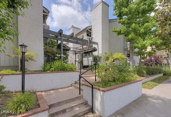 Front view of a multi-story building with a landscaped entrance.