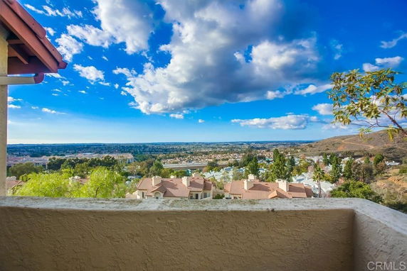Wide view from a building overlooking a residential area with hills in the background.