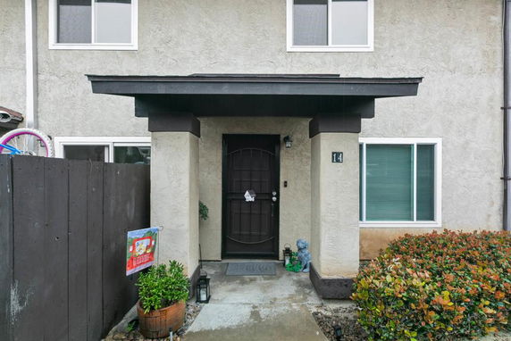 Front view of a two-story house with a dark door and overhang.
