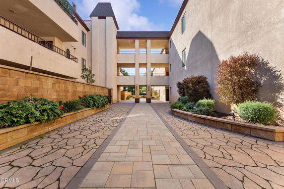 Front view of a multi-story building with an open pathway and landscaping.