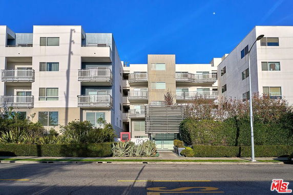 Front view of a multi-story modern apartment building with balconies.