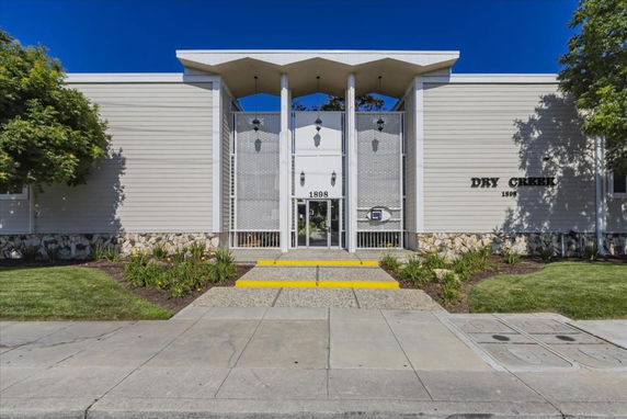Front view of a building with a symmetrical design, featuring large entryway and modern architectural elements.