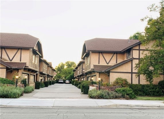 Front view of Tudor-style townhouses with driveways.