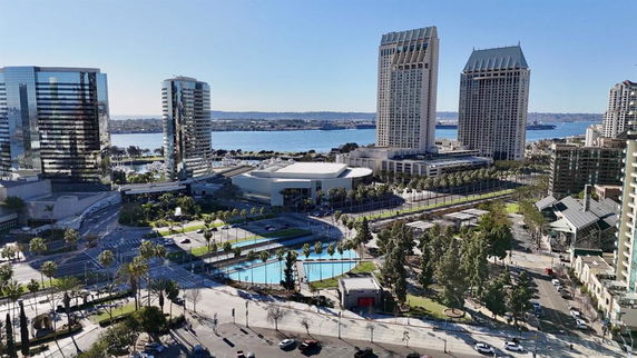 View of cityscape with tall buildings and a body of water in the background.