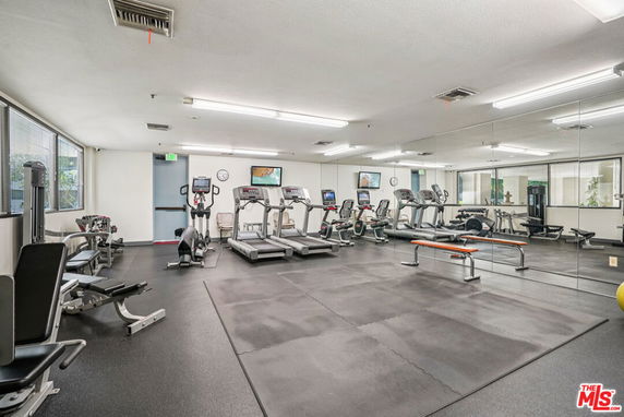 Indoor gym area with various exercise equipment including treadmills and weight machines.