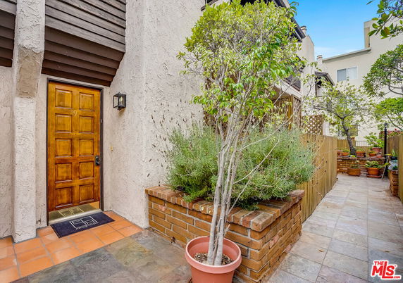 Front view of a house with a wooden door and stucco walls