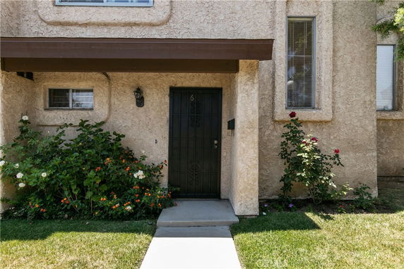 Front view of a house with a textured exterior wall and a black door.