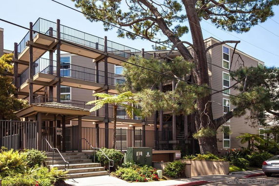 Front view of a multi-story apartment building with balconies and staircases.