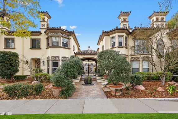 Front view of a two-story house with ornate architectural details and a gated entrance.