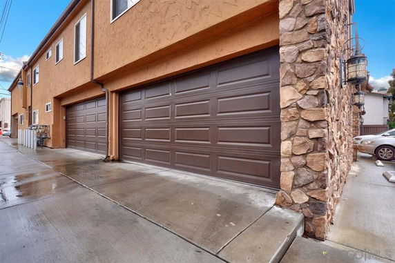 Outdoor parking area with garages in a residential building.
