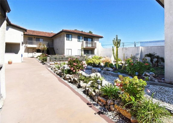 Front view of a two-story building with a garden and walkway.
