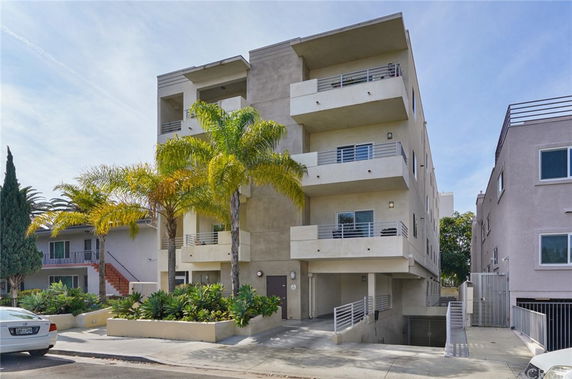 Front view of a multi-story apartment building with balconies.