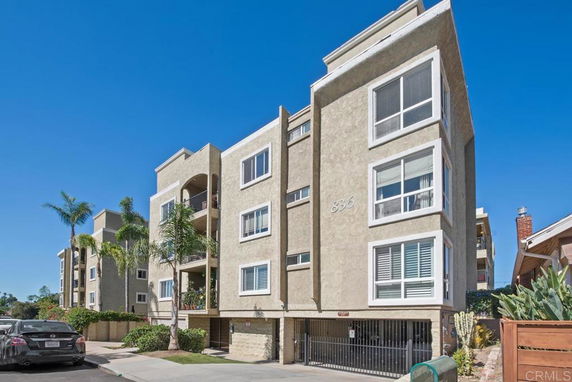 Front view of a multi-story apartment building with balconies.