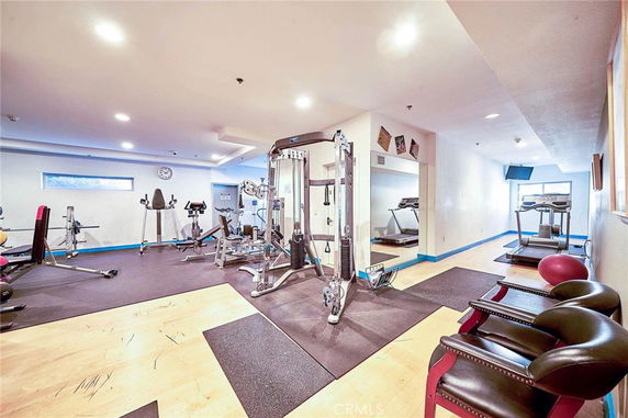 Interior view of a gym area with various exercise equipment including treadmills, weight machines, and exercise bikes.