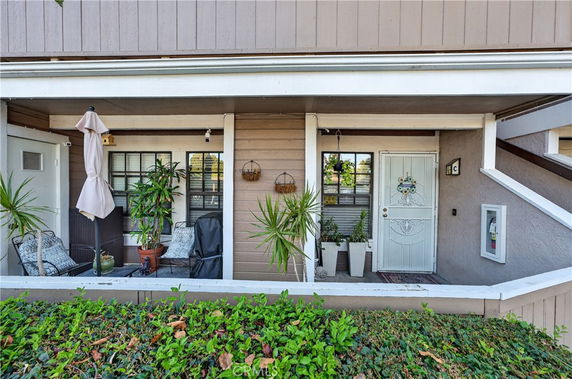Front view of a building with a small porch and potted plants.