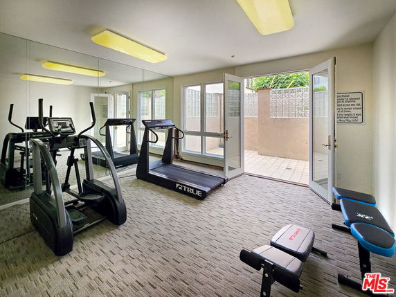 Indoor gym area with exercise equipment including treadmills and exercise bikes.