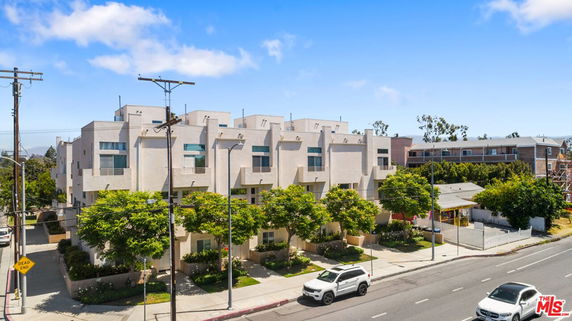 Front view of a multi-story residential building with multiple balconies.