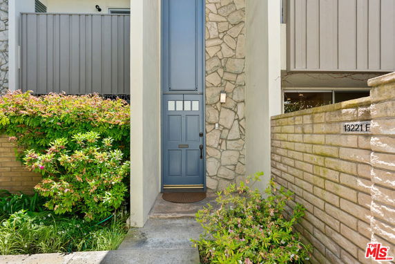 Front view of a house entrance with stone wall and blue door.