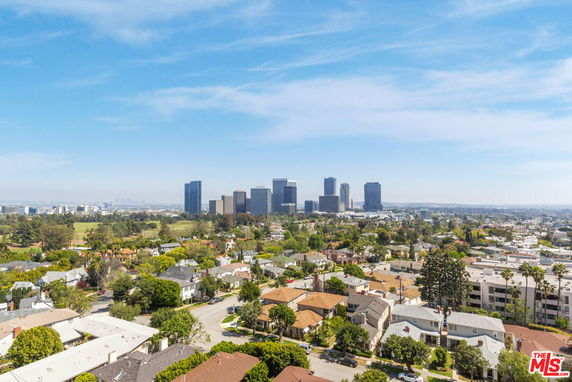 Panoramic view of a cityscape with a mix of buildings and greenery.
