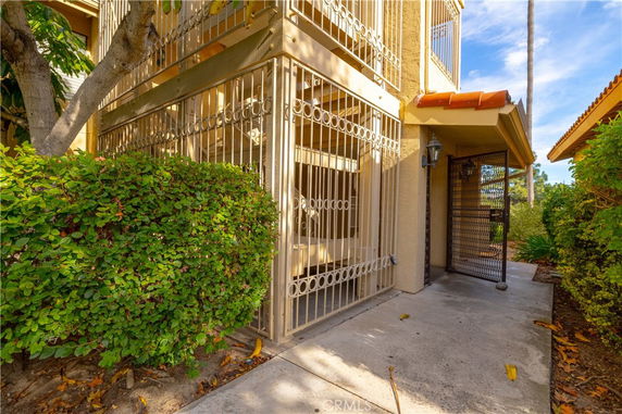Front view of a building with an iron gated entrance and covered walkway.