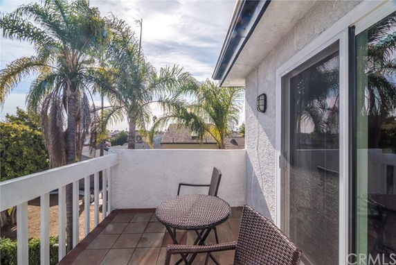 Rooftop balcony with a seating area and view of palm trees