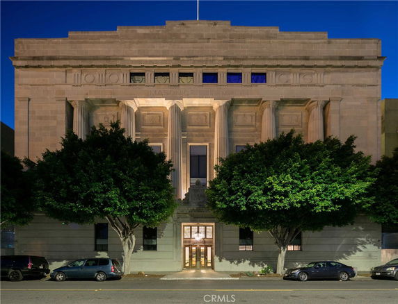 Front view of a large ornate building with columns and a grand entrance.