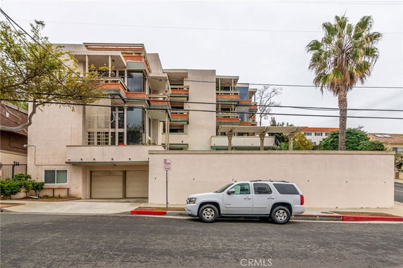 Front view of a multi-story modern residential building with balconies.