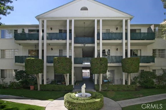 Front view of a three-story apartment building with columns and balconies.