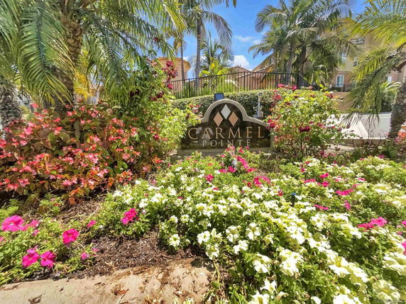 Front view of a building entrance with landscaping and a sign that reads 'Carmel Pointe'.