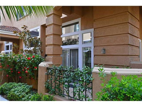 Front view of a residential building with large windows and a decorative garden.