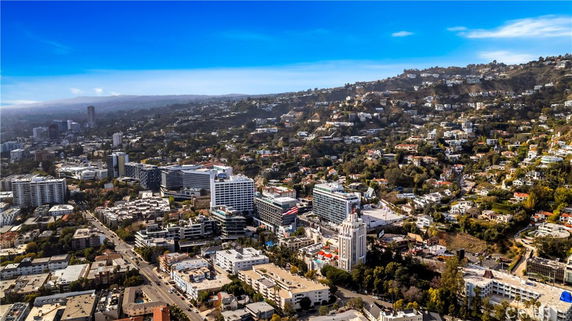 Panoramic view of a sprawling urban area with buildings and hills in the background.