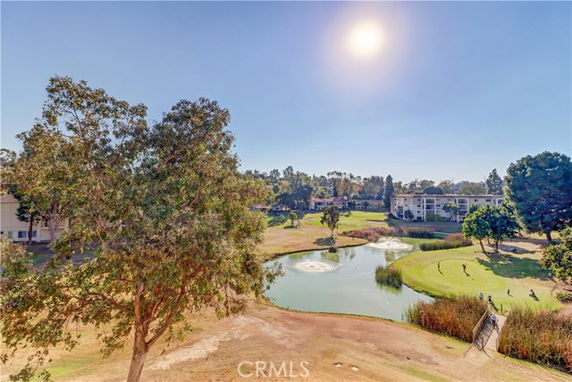 Scenic view of a golf course with buildings in the background.