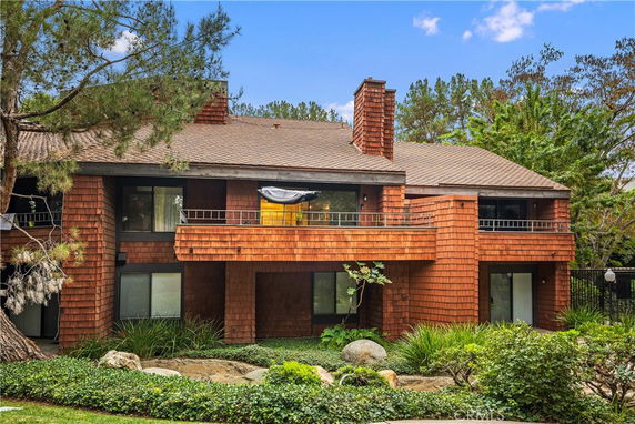 Front view of a two-story house with brick exterior and balcony.