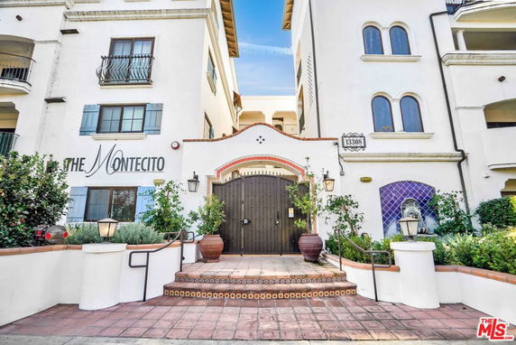 Front view of a multi-story residential building with a decorative gate entrance.