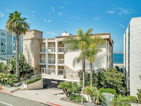 Front view of a multi-story building with balconies near the waterfront.