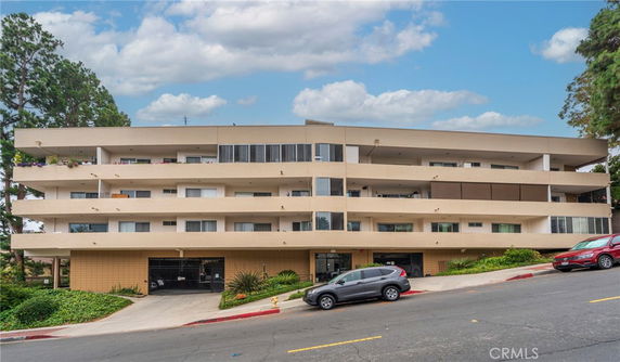 Front view of a multi-story apartment building with balconies on each floor.