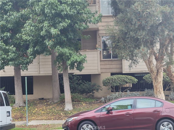 Front view of a multi-story apartment building with a small balcony.