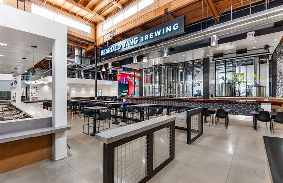 Interior view of a modern brewery with seating and industrial decor.