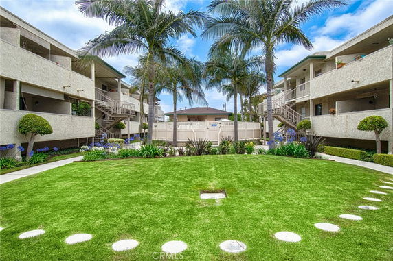 Courtyard view of a multi-story residential building with balconies and outdoor staircases.