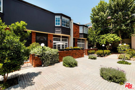 Front view of a two-story house with large windows and brick accents.