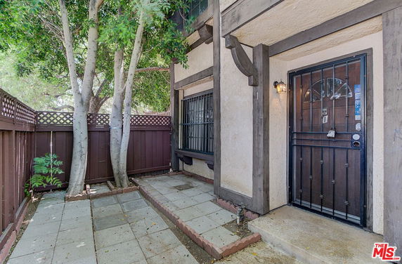 Front view of a building with a fenced entrance and a security door.